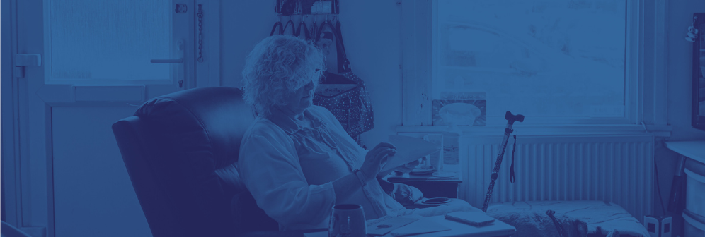 A person with a physical impairment, sat in their living room reading.